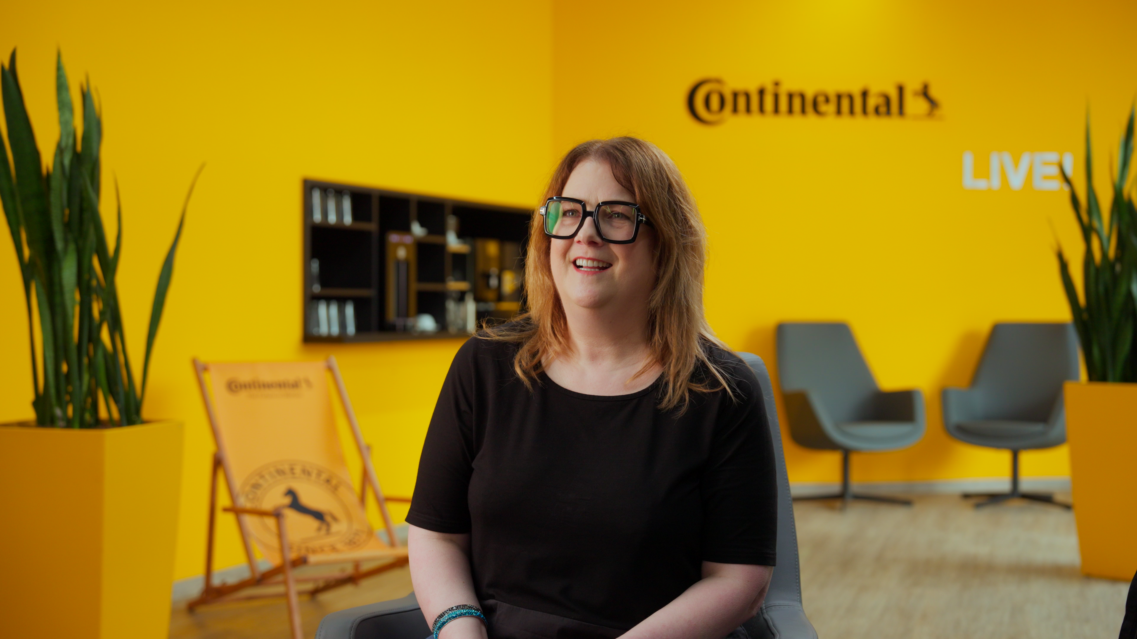 Mitarbeiterin von Continental im CITT Weiterbildungsprogramm lächelt zuversichtlich in die Kamera, im Hintergrund moderne Lernumgebung.